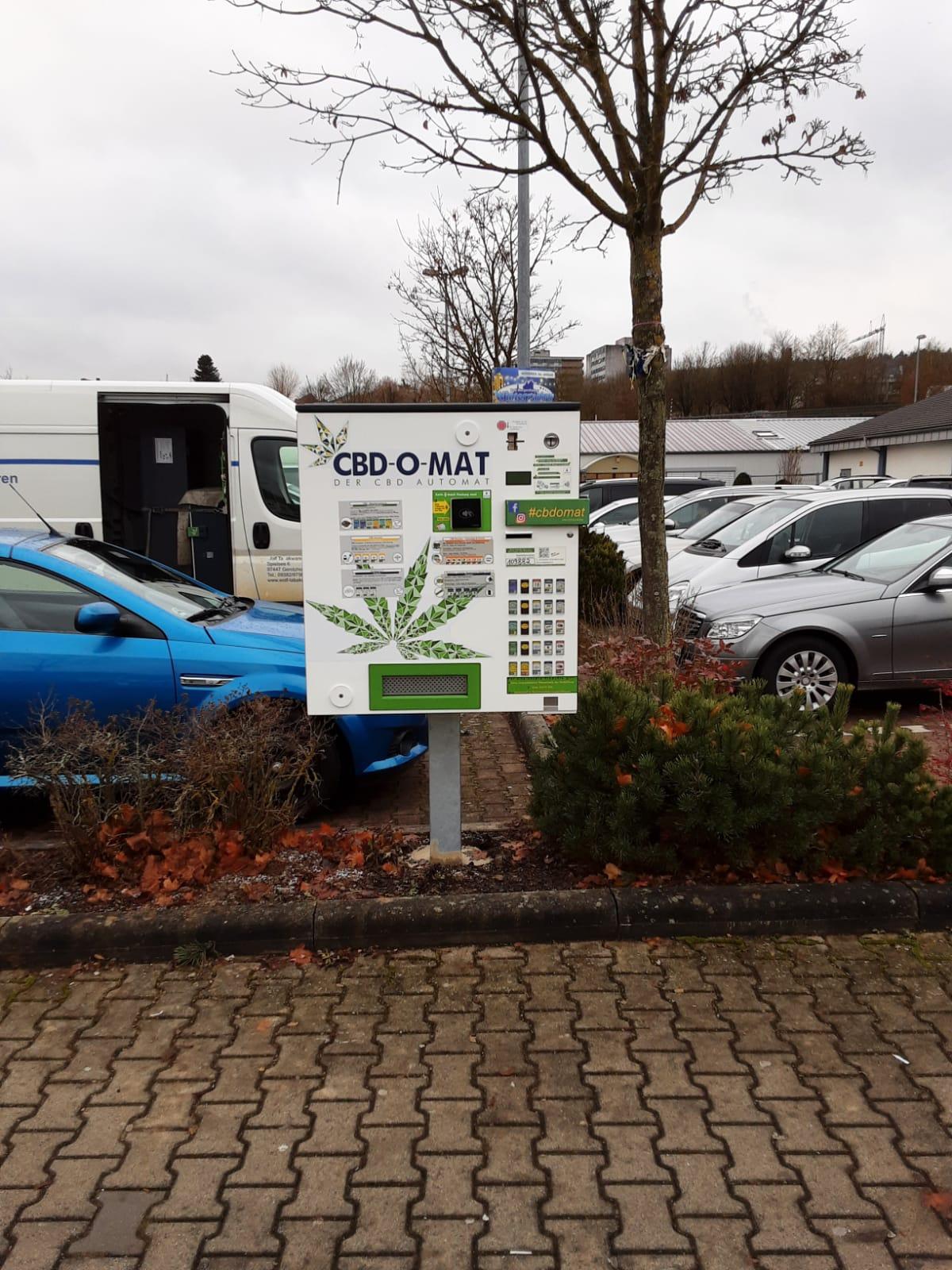 Foto von einem CBD-Automaten auf einem Ständer auf dem Grünstreifen eines Parkplatzes